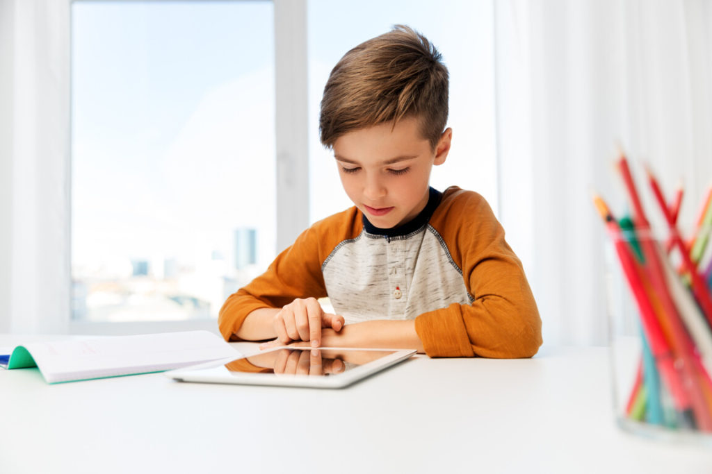 CyberReef Offers 6 FREE months of CIPA filtering Free Kids Internet Defense Shield being used by boy in orange shirt at tablet