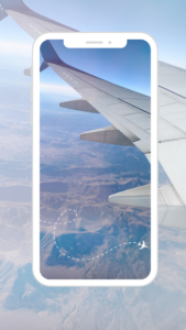 Travel Cybersecurity Tips Blog Mobile device framed in an airplane wing over mountains 